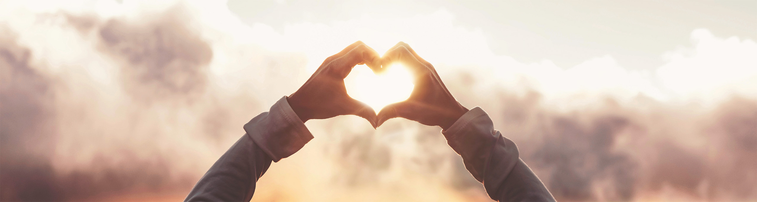 Herz aus Händen geformt vor stürmischem Himmel: Hilfe aus der Krise über Coaching und Seelsorge – persönlich (1:1) und online