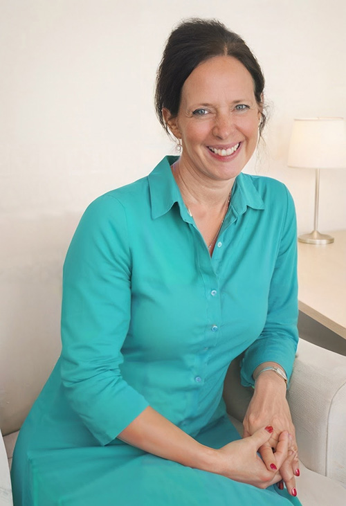 Eliane Douis (Gründerin) sitzt lächelnd auf einem Sessel: 15 Jahre Erfahrung in Krisenbewältigung, Beratung & Seelsorge.