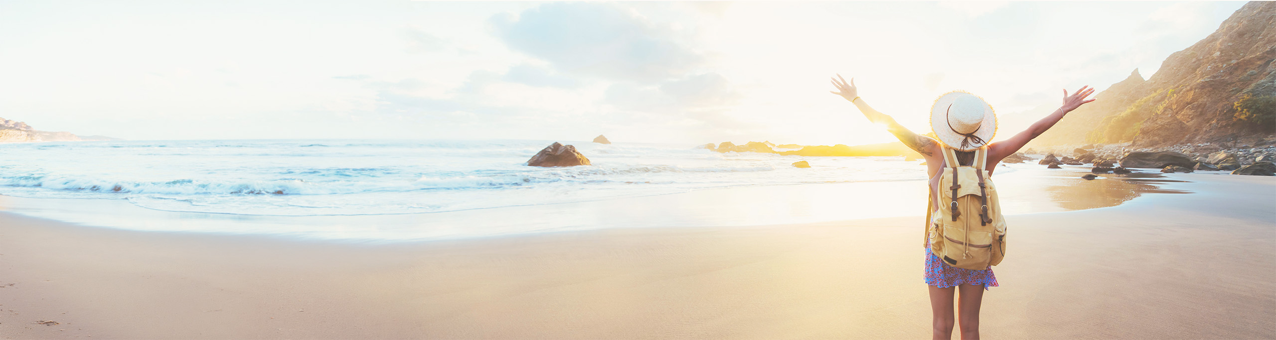 Glückliche Frau mit Rucksack angekommen am Meer: Die Reise zurück zu Dir und in die Fülle durch Coaching -Rems-Murr-Kreis oder online.